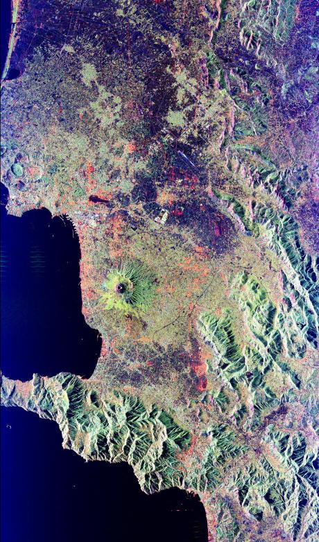 Mt. Vesuvius, one of the best known volcanoes in the world primarily for the eruption that buried the Roman city of Pompeii, is shown in the center of this radar image. The central cone of Vesuvius is the dark purple feature in the center of the volcano. This cone is surrounded on the northern and eastern sides by the old crater rim, called Mt. Somma. Recent lava flows are the pale yellow areas on the southern and western sides of the cone. Vesuvius is part of a large volcanic zone which includes the Phalagrean Fields, the cluster of craters seen along the left side of the image. The Bay of Naples, on the left side of the image, is separated from the Gulf of Salerno, in the lower left, by the Sorrento Peninsula. Dense urban settlement can be seen around the volcano. The city of Naples is above and to the left of Vesuvius; the seaport of the city can be seen in the top of the bay. Pompeii is located just below the volcano on this image. The rapid eruption in 79 A.D. buried the victims and buildings of Pompeii under several meters of debris and killed more than 2,000 people. Due to the violent eruptive style and proximity to populated areas, Vesuvius has been named by the international scientific community as one of fifteen Decade Volcanoes which are being intensively studied during the 1990s. The image is centered at 40.83 degrees North latitude, 14.53 degrees East longitude. It shows an area 100 kilometers by 55 kilometers (62 miles by 34 miles.) This image was acquired on April 15, 1994 by the Spaceborne Imaging Radar-C/X-Band Synthetic Aperture Radar (SIR- C/X-SAR) aboard the Space Shuttle Endeavour. SIR-C/X-SAR, a joint mission of the German, Italian and the United States space agencies, is part of NASA's  P-45742 July 13, 1995 